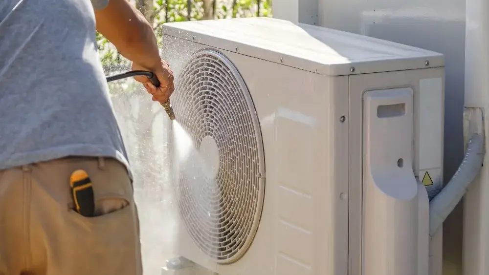 man cleaning outdoor unit